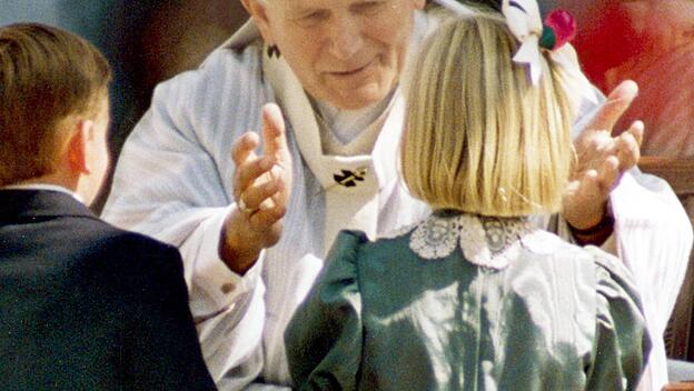 Papst Johannes Paul II. umarmt ein Mädchen während seines Besuchs in San Francisco