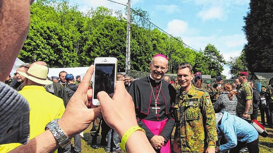 Militärbischof Franz-Josef Overbeck lässt sich mit einem Soldaten fotografieren.