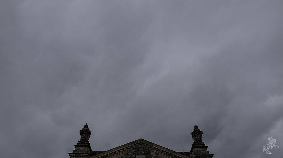 Symbolbild Bundestag vor grauen, dichten Wolken