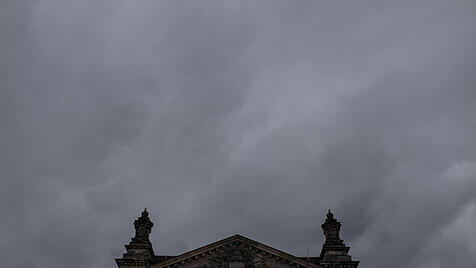 Symbolbild Bundestag vor grauen, dichten Wolken