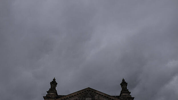 Symbolbild Bundestag vor grauen, dichten Wolken