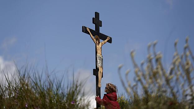 An boy kisses a crucifix on Good Friday at Penteli monastery, north of Athens