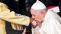 Papst Franziskus küsst einer ehemaligen Internatsschülerin die Hand.