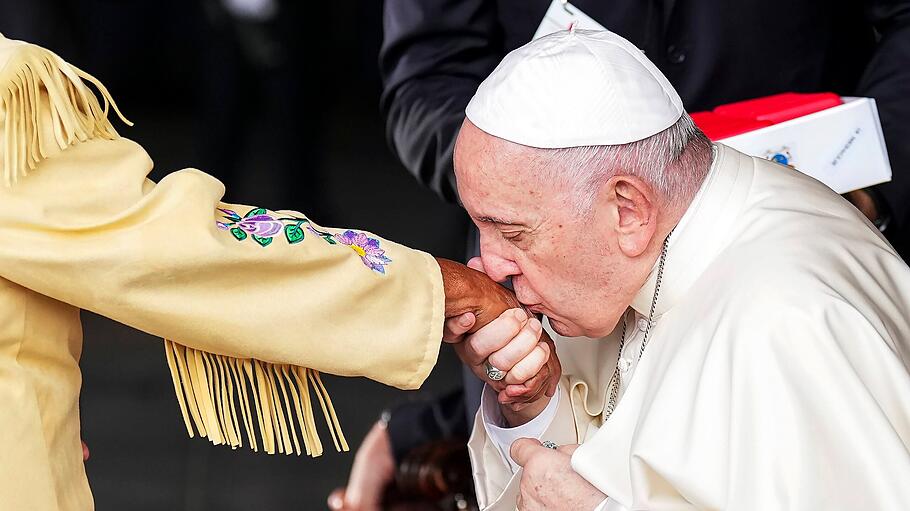 Papst Franziskus küsst einer ehemaligen Internatsschülerin die Hand.