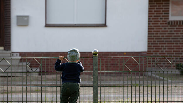 Einsames Kind am Zaun