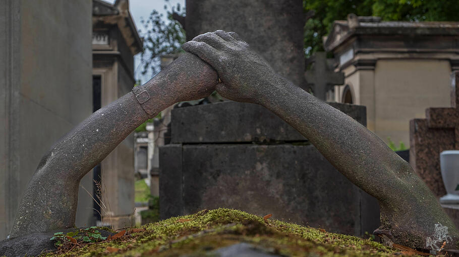 Auf dem Friedhof Pere LaChaise in Paris reichen sich Eheleute gusseiserne Arme.