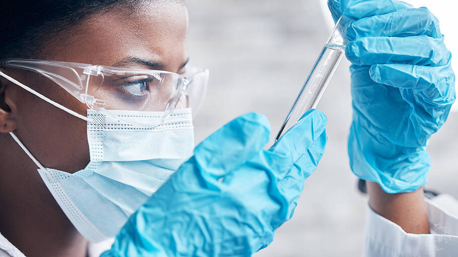 Black woman, scientist and research in lab with test tube for medical innovation and ppe safety for chemistry experiment. African lady, science and pharmaceutical study with liquid sample for vaccine