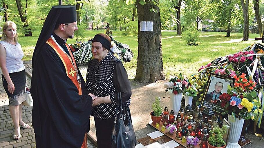Weihbischof Bohdan Dzyrakh tröstet die Mutter eines gefallenen Soldaten