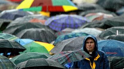 Rain beats down on a priest as he attends Pope John Paul II's general audience at the Vatican.