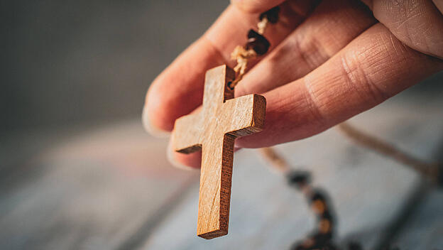 Rosenkranz in der Hand