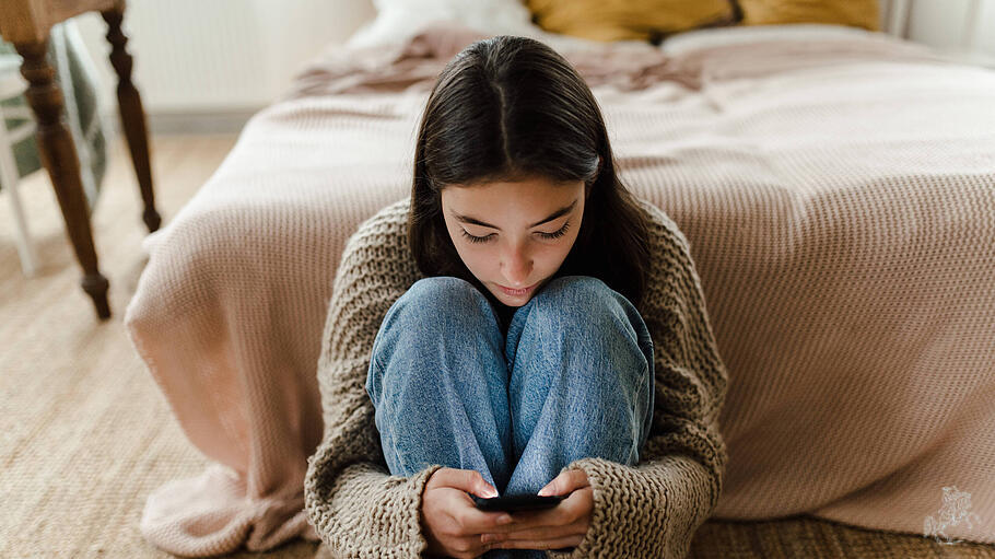 Ein Mädchen schaut auf sein Smartphone