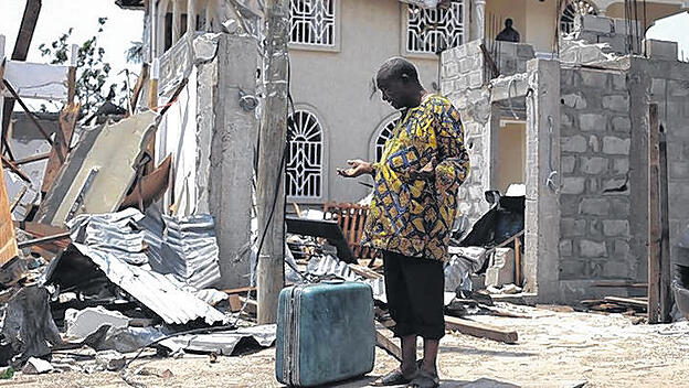 Überlebender vor einem zerstörten Haus einer Vorstadt von Brazzaville im Kongo.