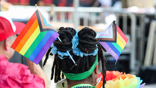 Eine Frau trägt Pride-Flaggen im Haar