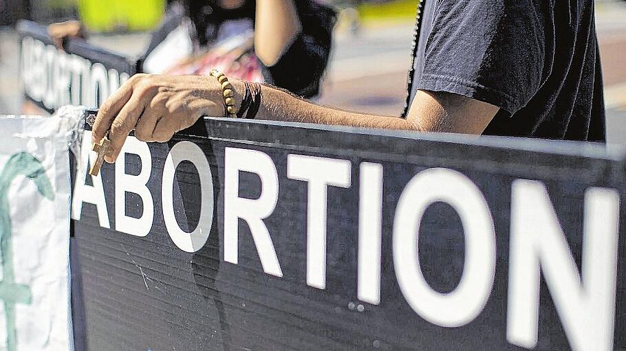 An activist holds a rosary while ralling against abortion outside City Hall in Los Angeles