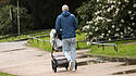 Vater fährt Kind im Kinderwagen