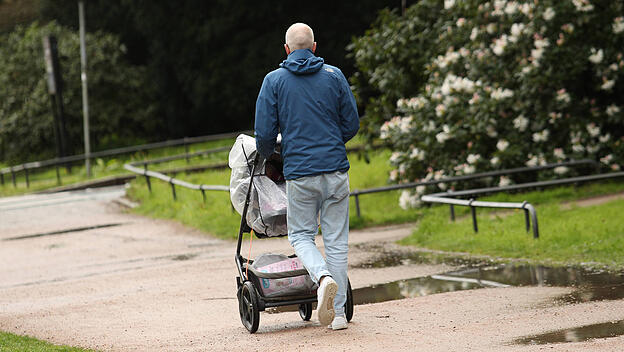 Vater fährt Kind im Kinderwagen