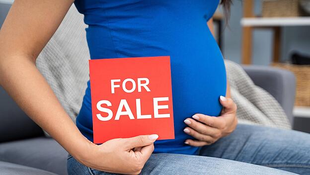 Schwangere Frau bietet ihr Baby zum Verkauf an