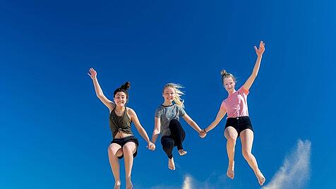 3 girls jump from a sand dune full of zest for life in the summer and whirl up dust Copyright: xfotofrankyx Panthermedia