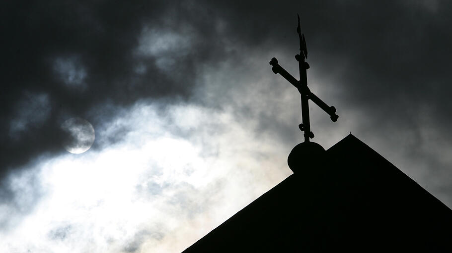 Eine Kirche vor einer dunklen Wolkenwand