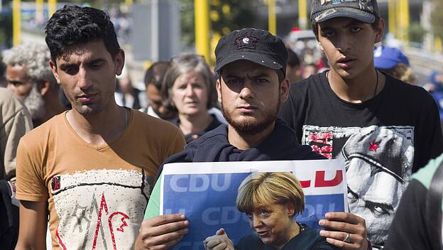 Flüchtlinge mit Merkel-Bild