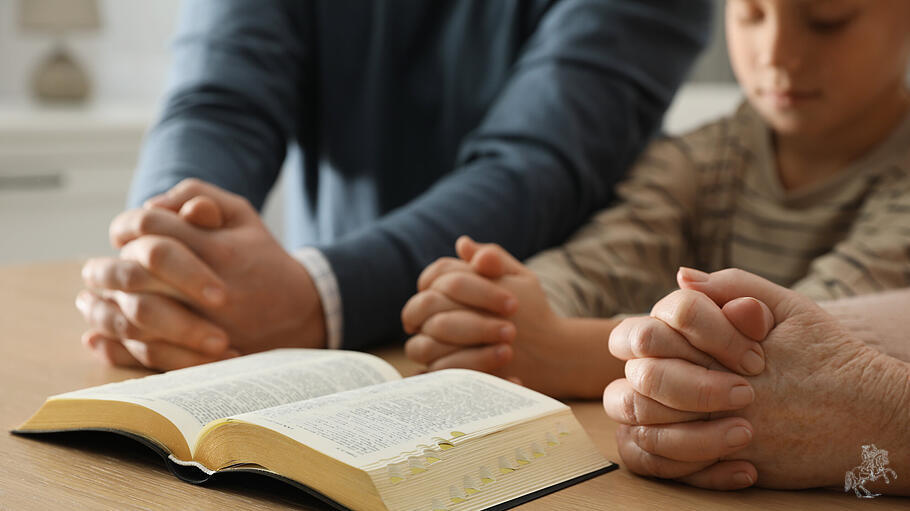 Boy  and  his  godparents  praying  together  at  wooden  table  indoors,  closeup   xkwx adult,  ba
