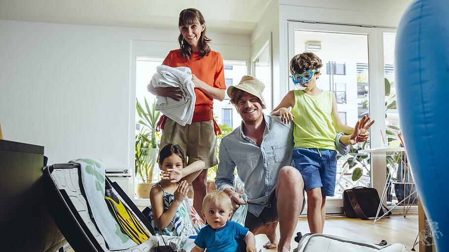 Eine Familie packt fröhlich für den Urlaub.