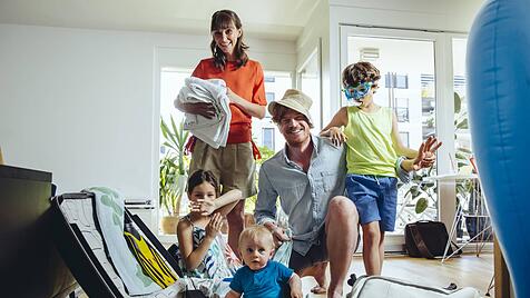 Eine Familie packt fröhlich für den Urlaub.