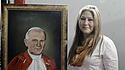 Floribeth Mora vor einem Bild von Papst Johannes Paul II.