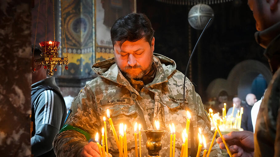 Ukrainischer Soldat entzündet Kerzen in der Wolodymyski-Kathedrale während der Osterfeierlichkeiten.