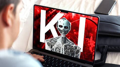 Ein Mensch schaut auf einen Bildschirm auf dem eine Künstliche Intelligenz mit einem humanoiden Roboter abgebildet ist