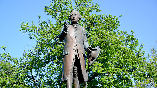 Monument to the philosopher Immanuel Kant against the background of foliage. Kaliningrad