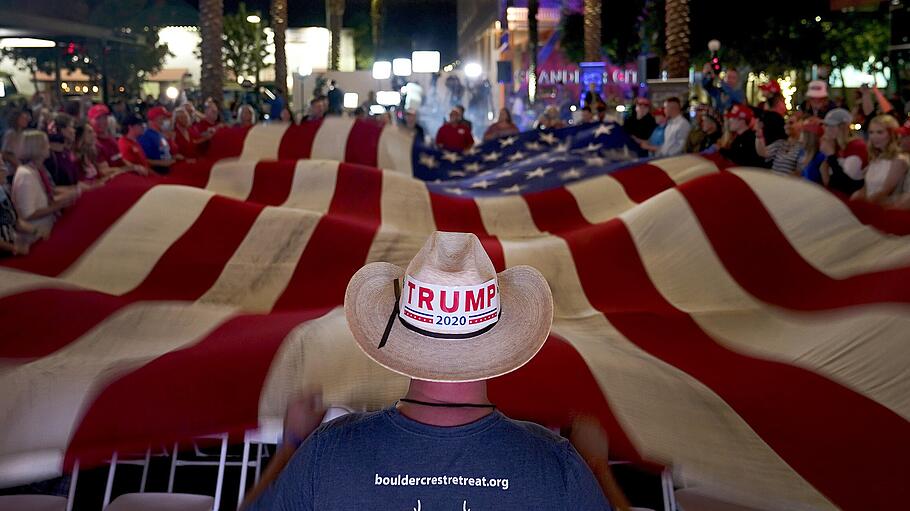 Anhänger von Präsident Donald Trump schwenken während einer Wahlparty eine Flagge