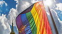 Regenbogenflagge vor Kirchturm