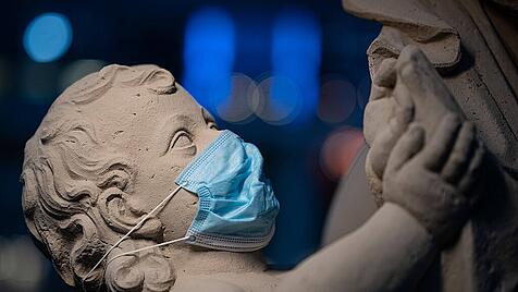 Eine barocke Sandsteinfigur im Dresdner Zwinger mit Atemschutzmaske