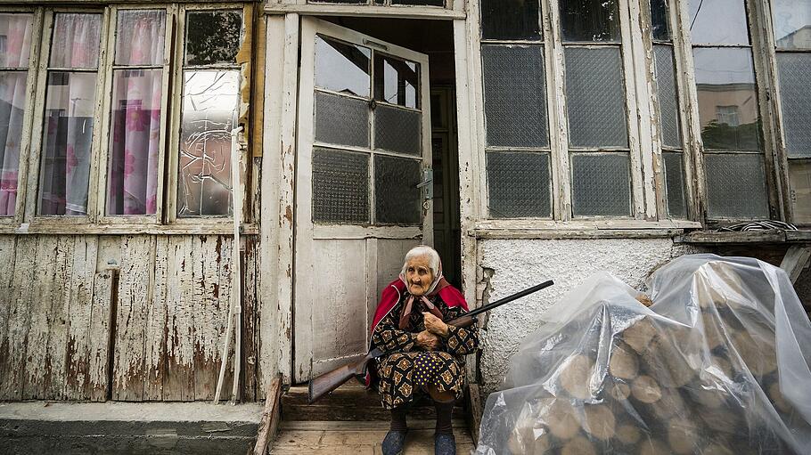 Berg-Karabach: Eine alte Frau sitzt mit einem Gewehr im Eingang ihres Hauses