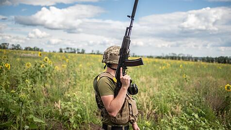 Ein Soldat verrichtet in einem Sonnenblumenfeld an der Frontlinie in Charkiw seinen Dienst