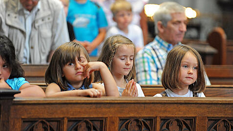 Kinder in einer Kirchenbank.