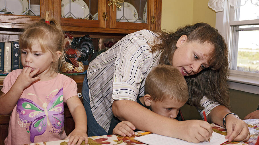 Christa Keagle works with her children Rebekah and Joshua Keagle during a homeschool assignment in St. Charles, Iowa