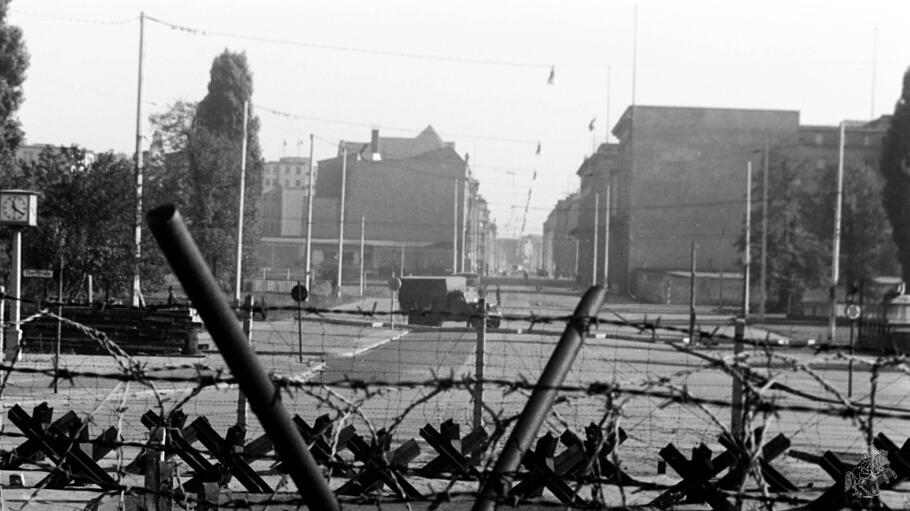 Ein Blick durch Stacheldraht &uuml;ber die Mauer in den Ostteil von Berlin