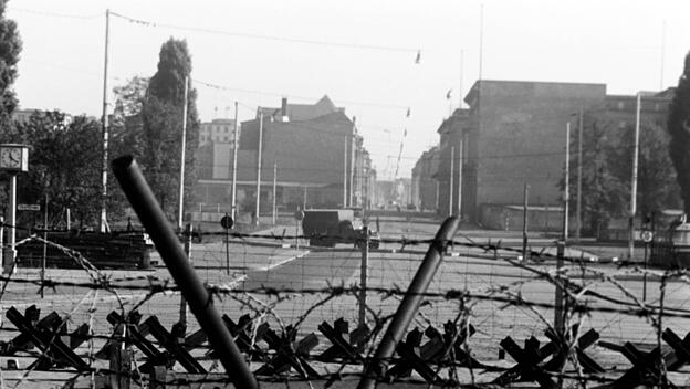 Ein Blick durch Stacheldraht &uuml;ber die Mauer in den Ostteil von Berlin