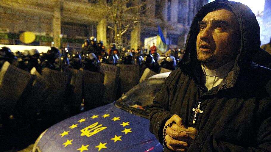 Ein Mann betet bei Bürgerprotesten auf dem Maidan in Kiew (Ukraine)