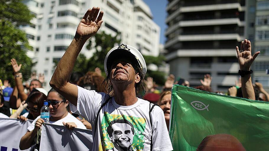 Supporters of presidential candidate Jair Bolsonaro pray during a demonstration after he was stabbed, in Rio de Janeiro