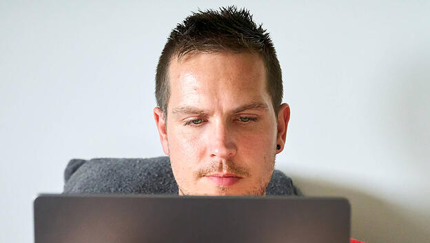 Junger Mann vor Laptop