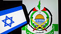 Das Emblem der Hamas neben der israelischen Flagge.