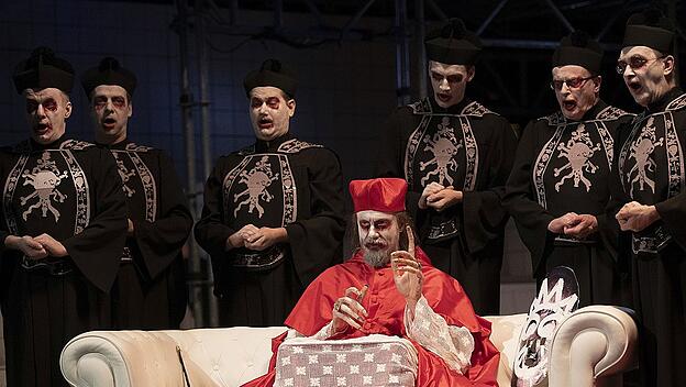 Opernprojekt  Halle: Zuerst trug der Bischof (Michael Zehe) eine Schamanenmaske, dann rotes Birett