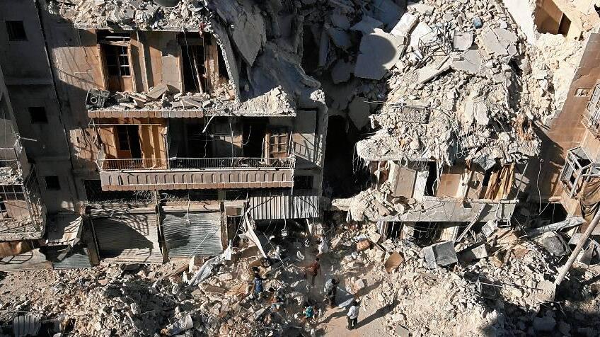 FILE PHOTO: People dig in the rubble in an ongoing search for survivors at a site hit previously by an airstrike in the rebel-held Tariq al-Bab neighborhood of Aleppo