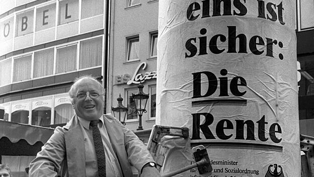 Norbert Blüm klebt Rentenplakat an Litfaßsäule