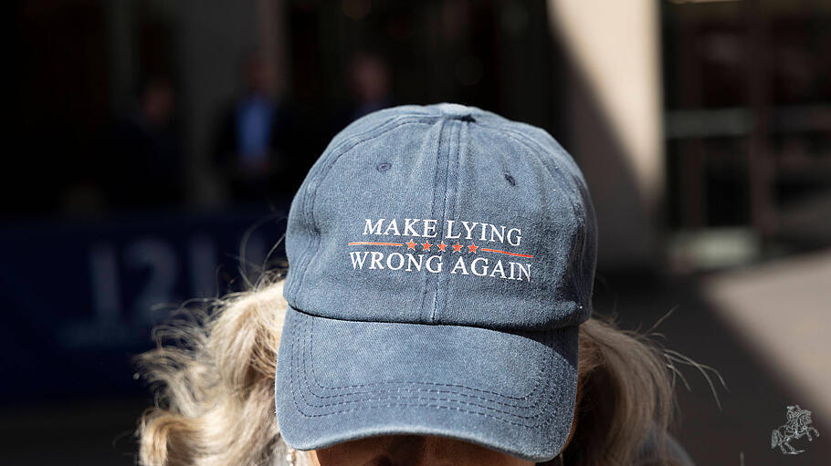 Demonstrant gegen die Regierung Trump trägt eine Kappe mit der Aufschrift „MAKE LYING WRONG AGAIN"