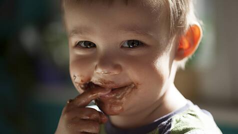 Smiling little boy eating chocolate model released Symbolfoto PUBLICATIONxINxGERxSUIxAUTxHUNxONLY ZE