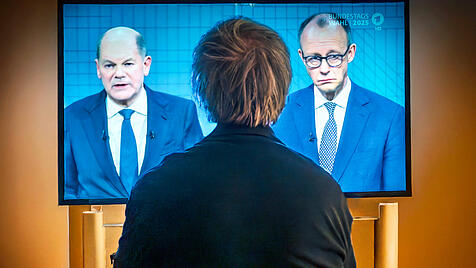 Zuschauer verfolgt TV-Duell zwischen den Kanzlerkandidaten Scholz und Merz